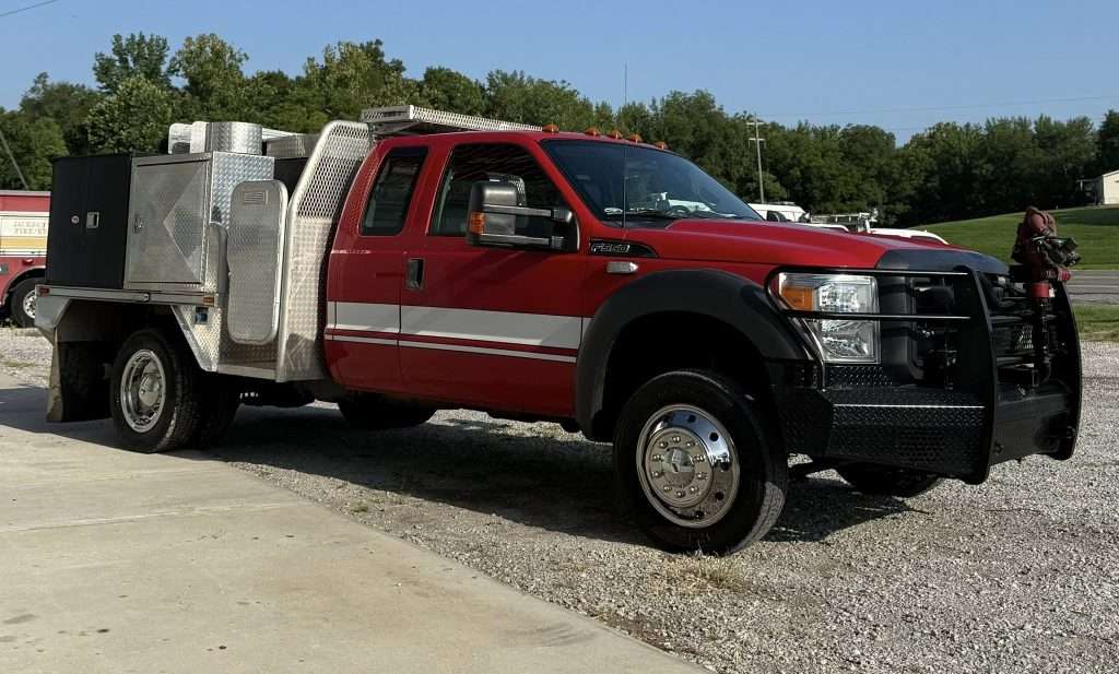 Used fire truck from one of many trusted fire truck manufacturers featuring a Ford chassis with utility body and front-mounted pump.